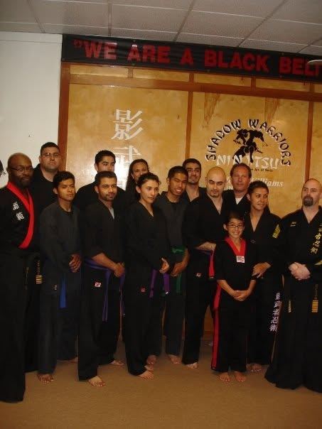 Black belt lineup under We Are a Black Belt School banner