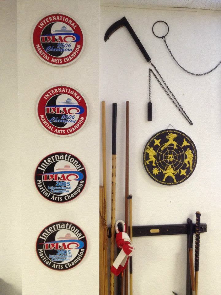 Championship medallions and traditional weapons wall